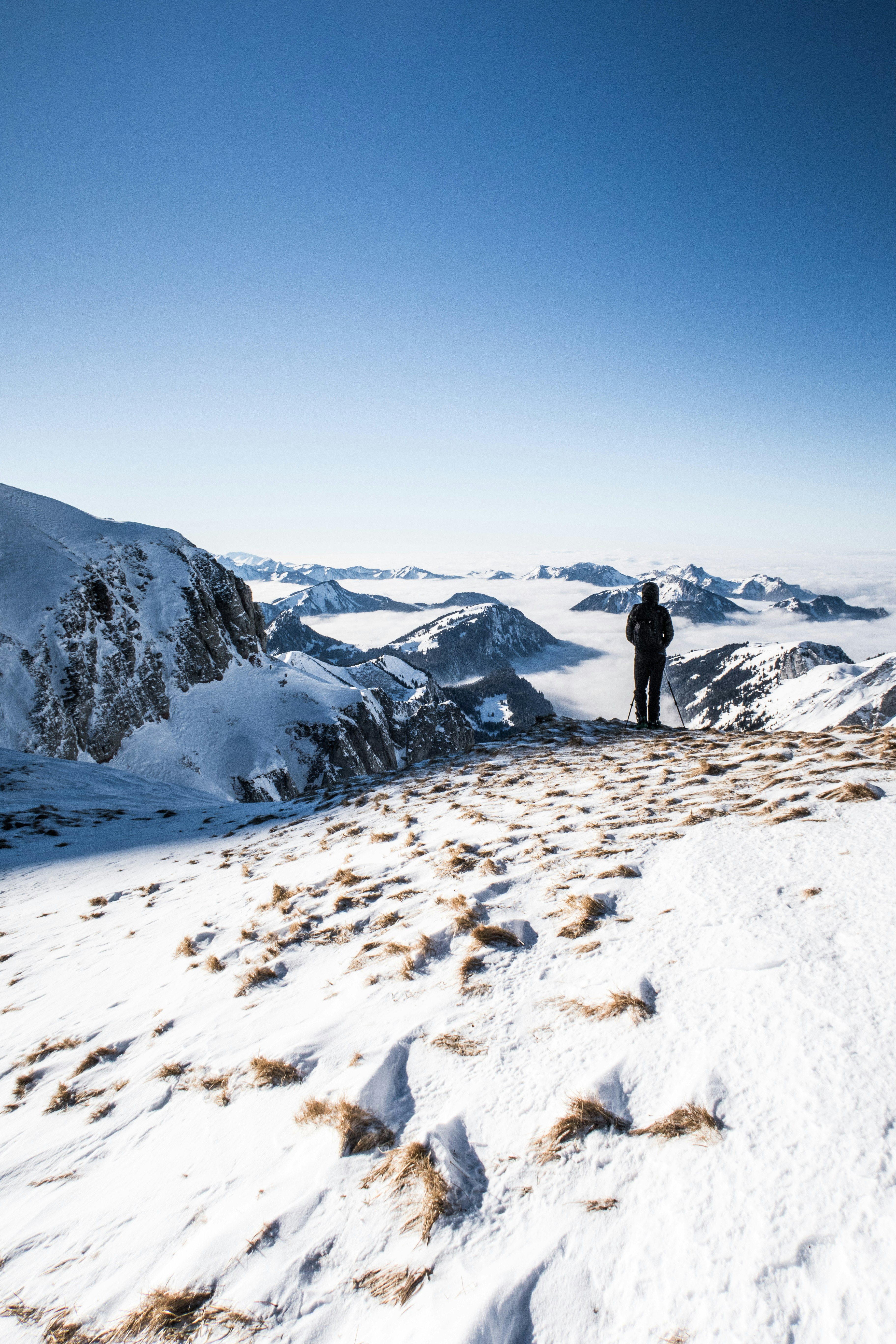 person in black jacket standing on snow covered ground during daytime